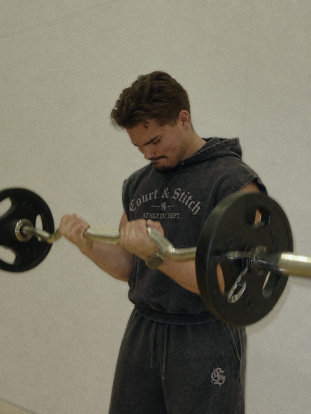Court & Stitch sleeveless hoodie during a barbell curl