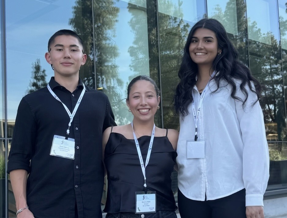 Ryan with co-authors Savanna Batto and a teammate at the symposium